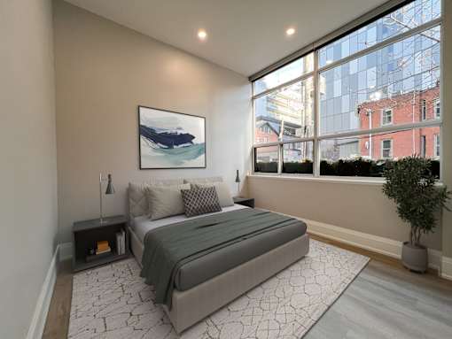 A bedroom with a large bed and a painting on the wall.