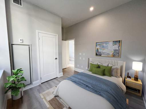 A bedroom with a bed, nightstand, and a painting on the wall.