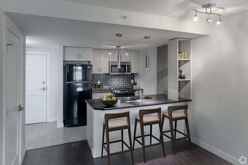 A kitchen with a bar stool in front of the island.