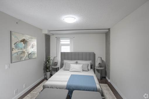 A bedroom with a large bed and a painting on the wall.