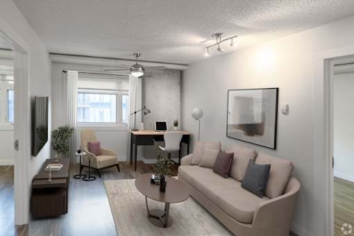 A living room with a couch, chair, and desk.