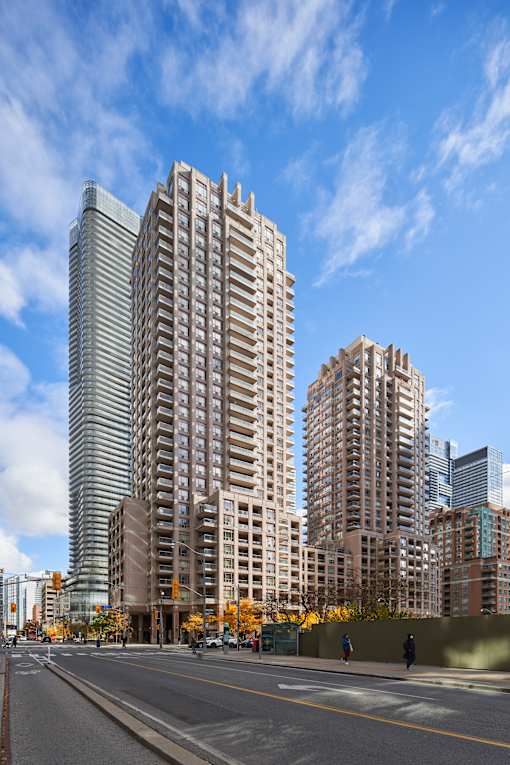 Two tall buildings stand next to each other with a street in front of them.