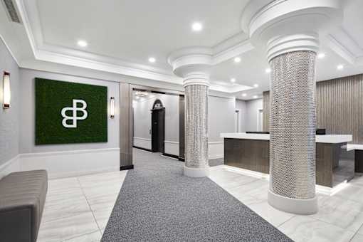 A reception area with a green sign with a white letter B on it.
