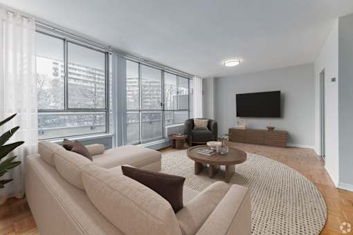A living room with a large couch, a coffee table, and a flat screen TV.