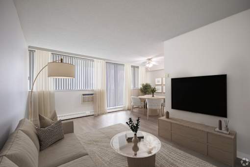 A modern living room with a large couch, a coffee table, and a flat-screen TV.