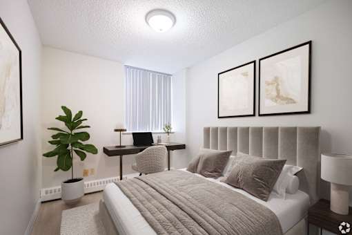 A bedroom with a large bed and a desk with a chair.
