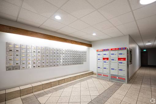 A hallway with a row of mailboxes on the wall.