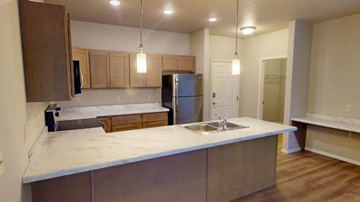 A kitchen with a sink and a refrigerator.
