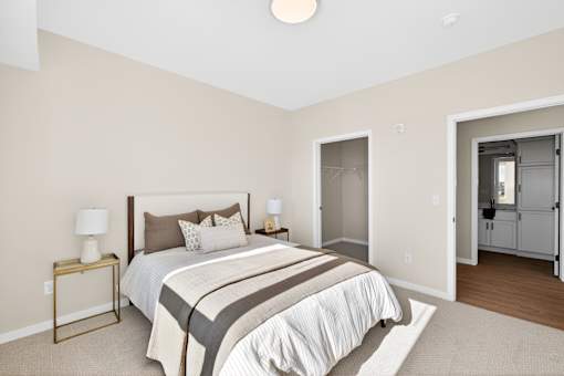 A bedroom with a bed, nightstand, and closet.