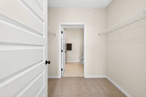A white door is open to a small bathroom.