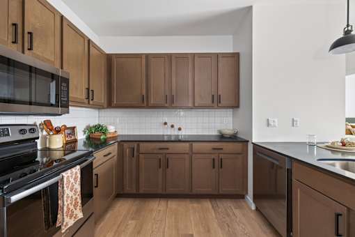 A kitchen with brown cabinets and a black stove top.