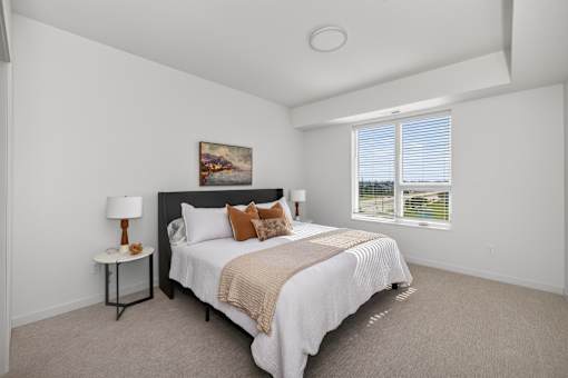 A bedroom with a large bed and a painting on the wall.
