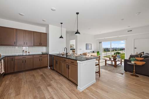 A modern kitchen with wooden floors and a large island.