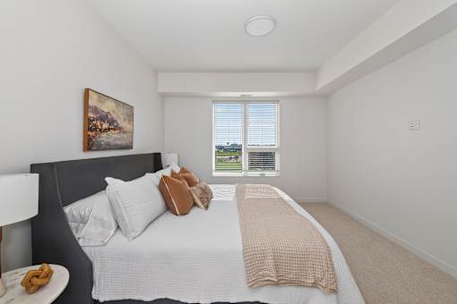 A bedroom with a large bed and a painting on the wall.