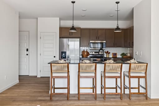 A kitchen with a bar stool in front of the island.