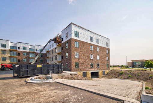 A large building under construction with a red truck parked in front.