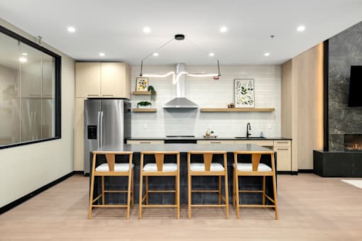 A modern kitchen with a large island and wooden bar stools.