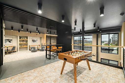 A room with a table and chairs and a view of the outside.