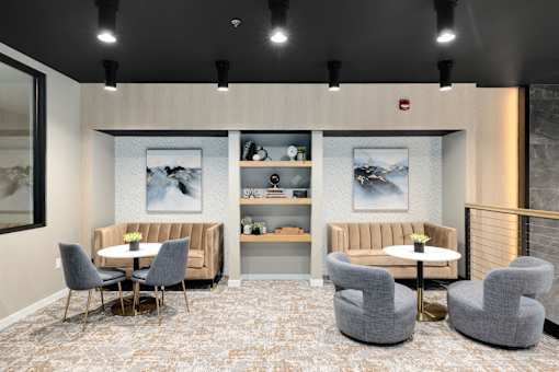 A modern waiting room with grey chairs and a white table.