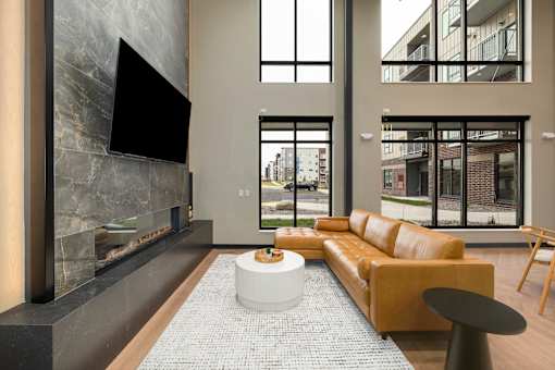 A modern living room with a fireplace and a large flat screen TV mounted on the wall.