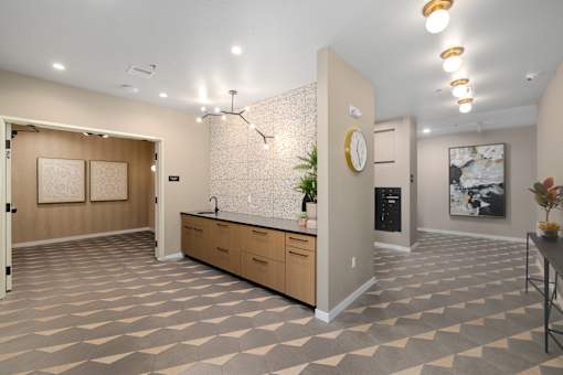 A kitchen area with a checkered floor and a wall clock.