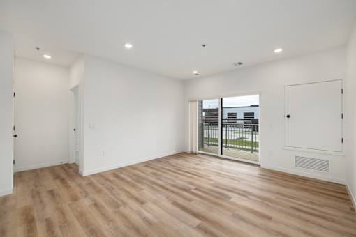 A room with wooden flooring and white walls.