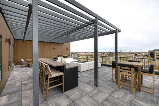 A patio with a table and chairs under a roof.