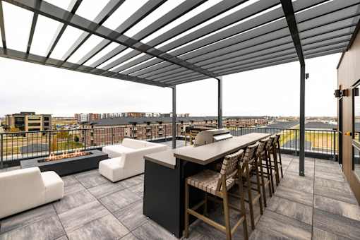 A patio with a table and chairs overlooking a city.