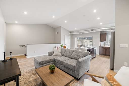 A modern living room with a grey sofa and a wooden coffee table.
