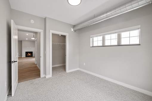 A spacious room with a fireplace and a window.
