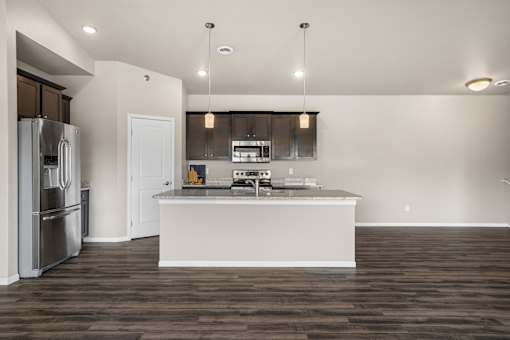 A modern kitchen with a white island and stainless steel appliances.