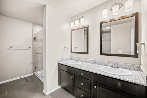 A bathroom with two sinks and a large mirror.
