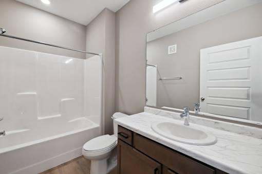 A bathroom with wood toned vanity
