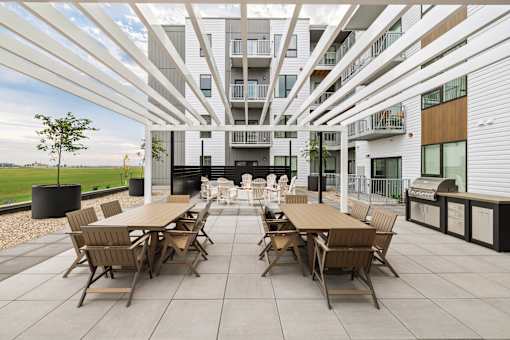 A patio with a table and chairs is in front of a building.