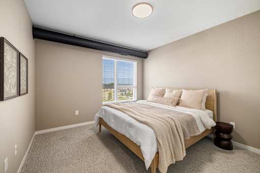 A bedroom with a large bed and a window overlooking the ocean.