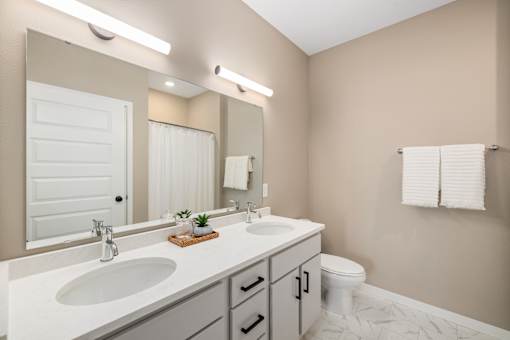 A bathroom with a white sink and a white toilet.