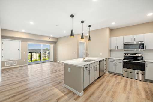 A kitchen with a sink, stove, and oven.