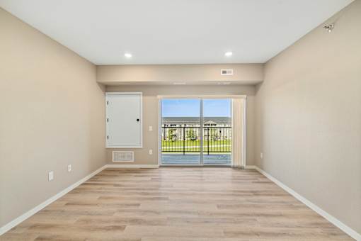 A room with a sliding glass door leading to a balcony.