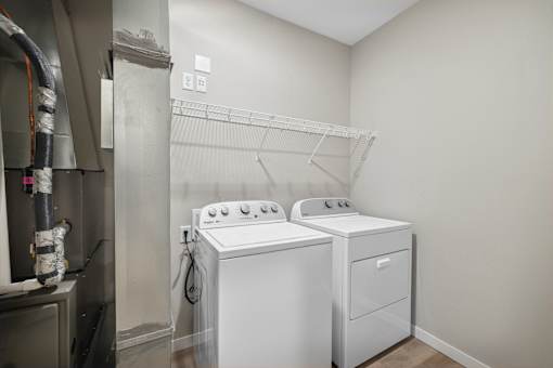 an empty laundry room with two washes and a dryer in a rental apartment