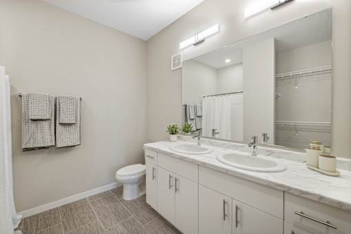 a bathroom with a large mirror and a toilet and sink