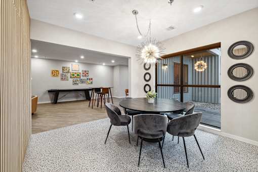 a dining area with a round table and chairs and a glass sliding door