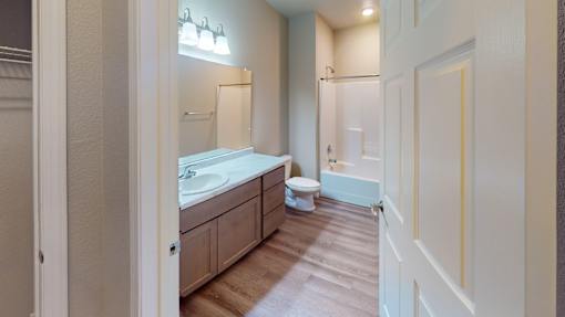 A bathroom with a toilet, sink, and mirror.