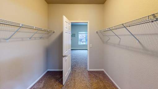 A room with a white door and two metal racks on the wall.