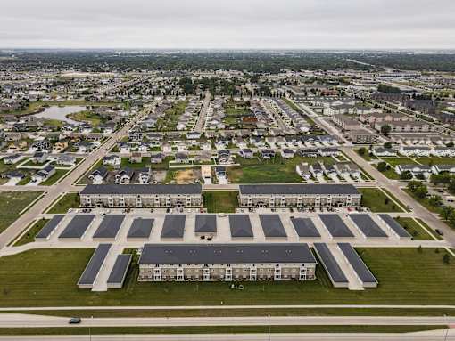 A large building complex with a parking lot in front.