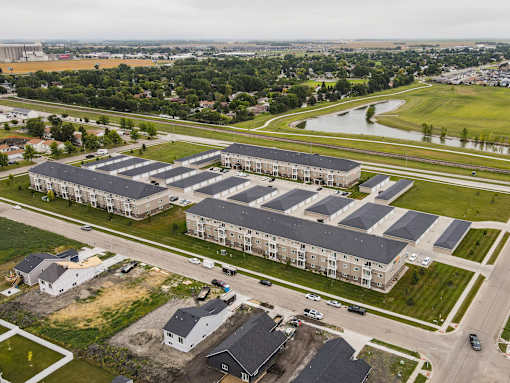 A large apartment complex with multiple buildings and a parking lot in front.