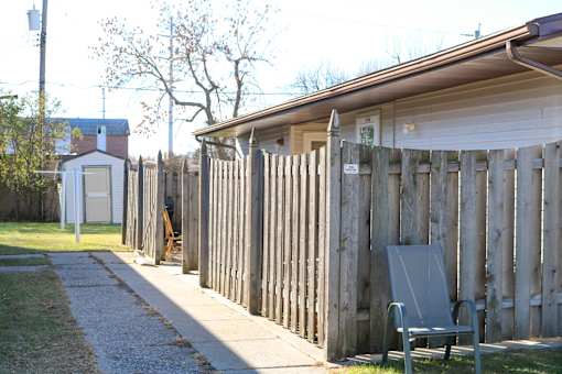 A wooden fence with a bench in front of it.