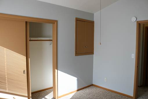 A room with a brown door and a white wall.