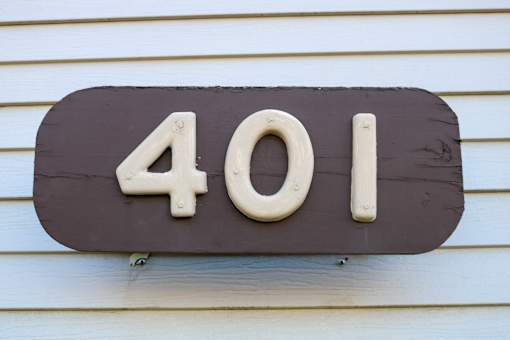 A brown house number sign with the number 401 on it.