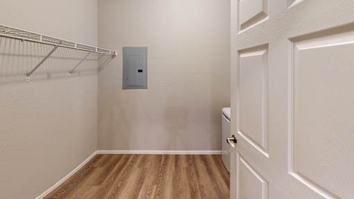 A white door is on the right and a white shelf is on the left.