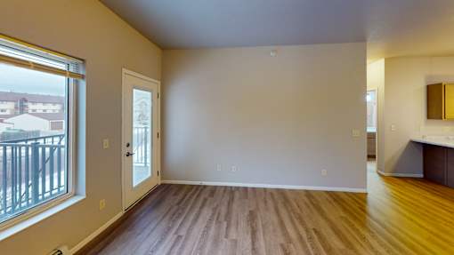 A room with wooden floors and a large window.